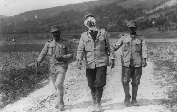 Doi soldați români ajută un tovarăș rănit să se întoarcă la o stație de ajutor de lângă Cașin, 1917.